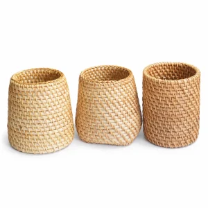 Handwoven rattan desk cup selection in tapered, square-base and straight shapes on white
