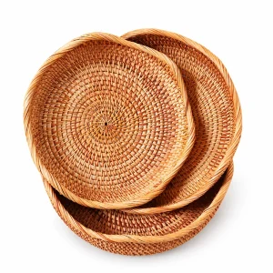 Three handwoven round rattan fruit baskets with petal rims on white background