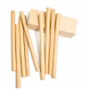 Natural bamboo drinking straws arranged beside a wooden block on white