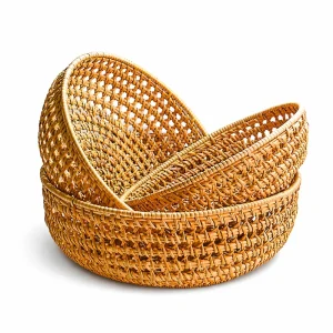 Three nested handwoven natural rattan baskets on a white background