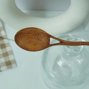 Close view of the oval wooden spoon bowl, natural grain and triangular opening