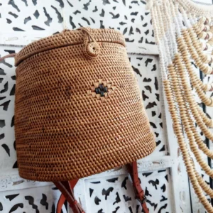 Close view of the rattan backpack weave, dark motif and woven button
