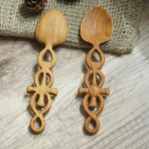 Two cross-motif wooden spoons showing handcrafted variation
