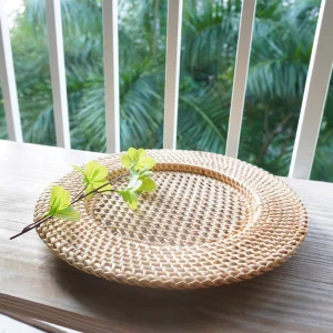 Handwoven Rattan Charger Plate 4 Low side view of the shallow woven rattan plate on a wooden table