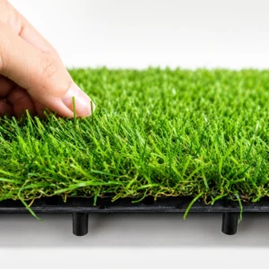 Close-up of green synthetic grass fibres and raised plastic tile base