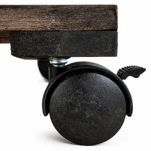 Close-up of a black locking caster under the dark acacia platform