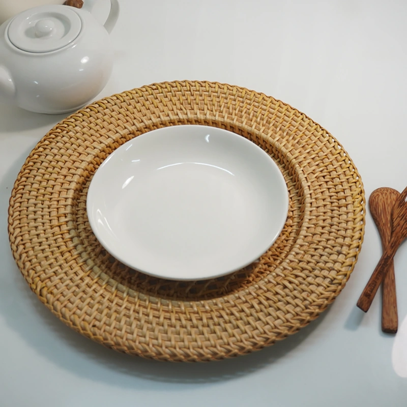 Handwoven Rattan Charger Plate 6 Rattan charger plate beneath a white dinner plate beside wooden cutlery
