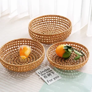 Three handwoven rattan baskets displaying fruit and small items