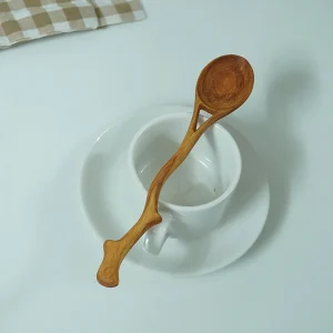 Y-shaped wooden spoon styled across a white cup and saucer