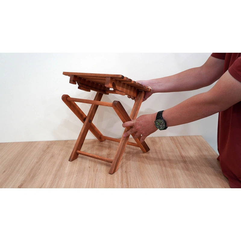 Folding Acacia Side Table with Slatted Top – 37 cm 6 Hands demonstrating how the cross legs of the acacia side table fold