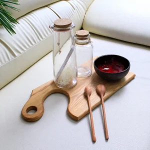 Additional styled view of the red feather-effect bowl; glass jars, wooden board and spoons are presentation props.