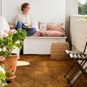 Golden acacia deck tiles covering a balcony seating area with plants