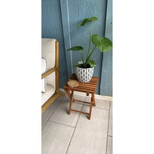 Folding Acacia Side Table with Slatted Top – 37 cm 1 Compact folding wooden side table used as a plant display beside a chair