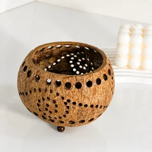 Coconut shell tealight candle holder styled beside a decorative candle