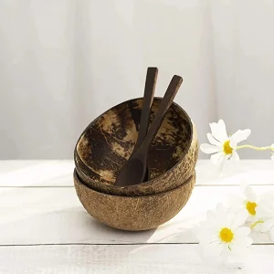 Coconut shell bowl and wooden spoons styled on a table with flowers