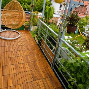 Natural acacia deck tiles installed along a green balcony