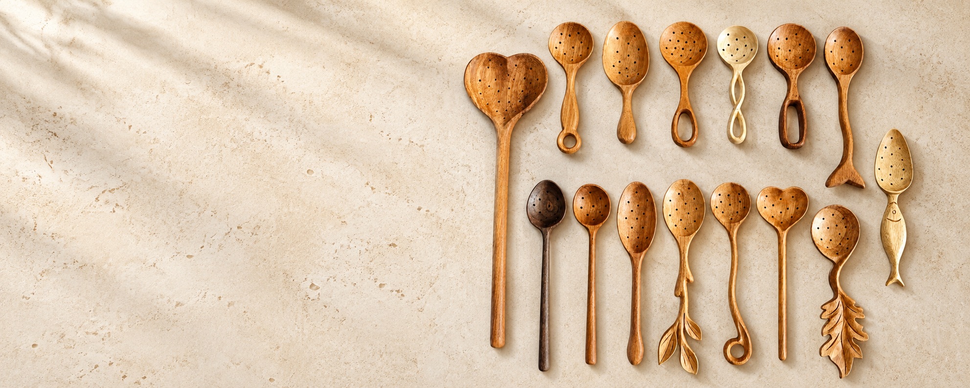 Decorative carved wooden spoons arranged on a cream stone surface