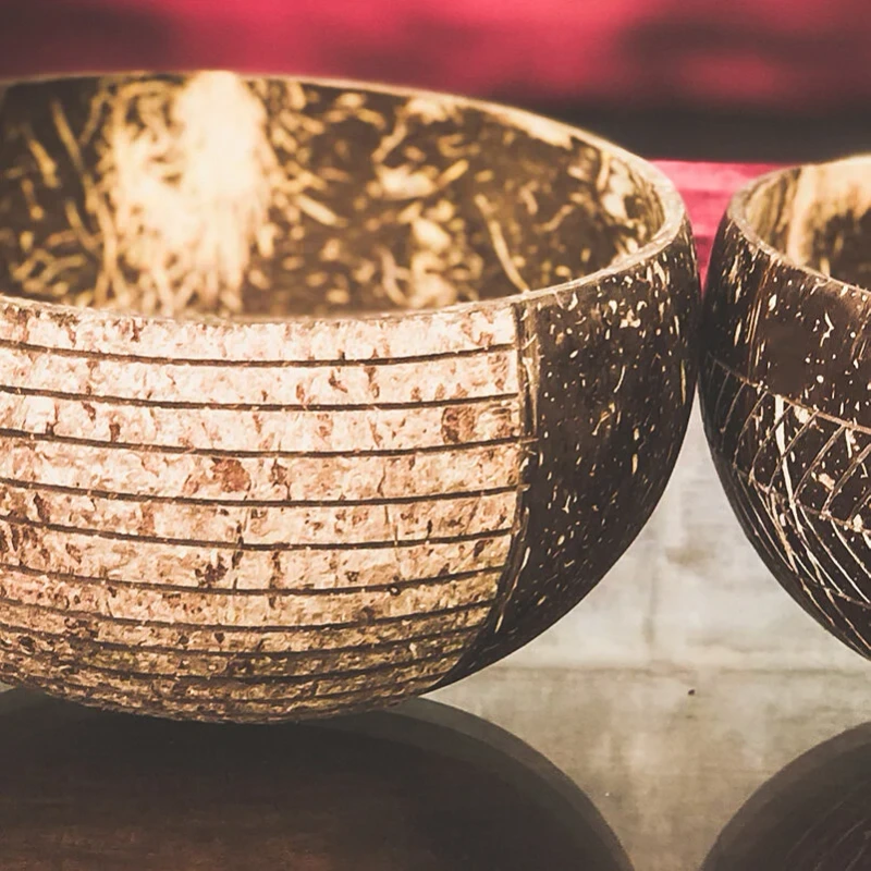 Stripe Carved Natural Coconut Bowl 5 Close view of carved coconut bowls on a reflective table