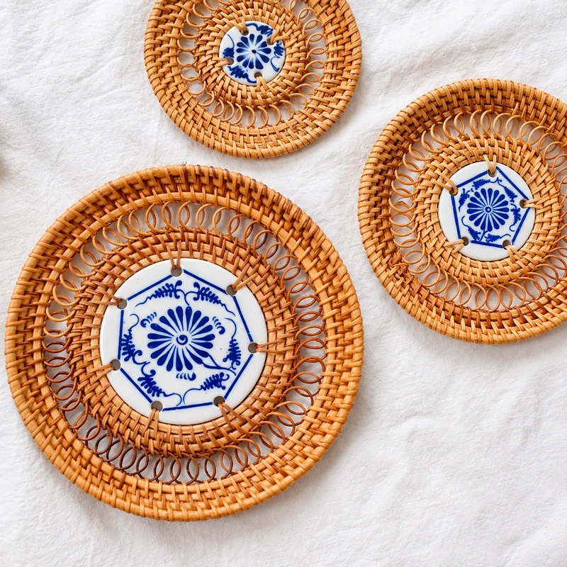 Ceramic-centred rattan coasters on white fabric Ceramic-centred rattan coasters on white fabric