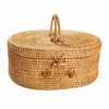 oval lidded rattan basket on a white background